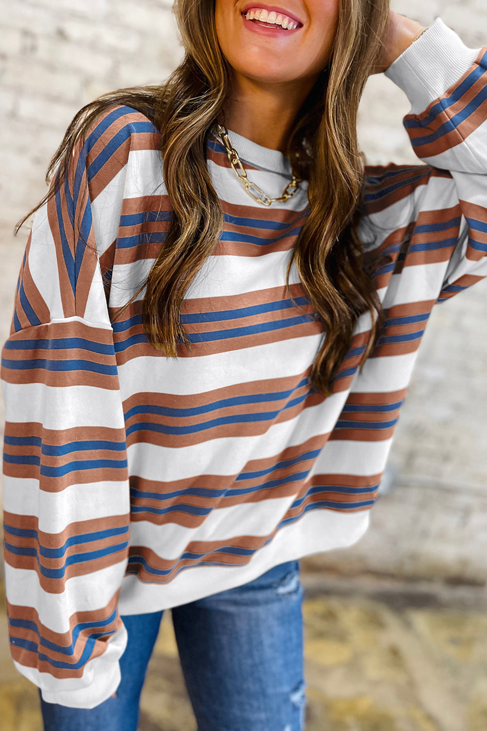 Woman wearing a striped long-sleeve top with a blurred background