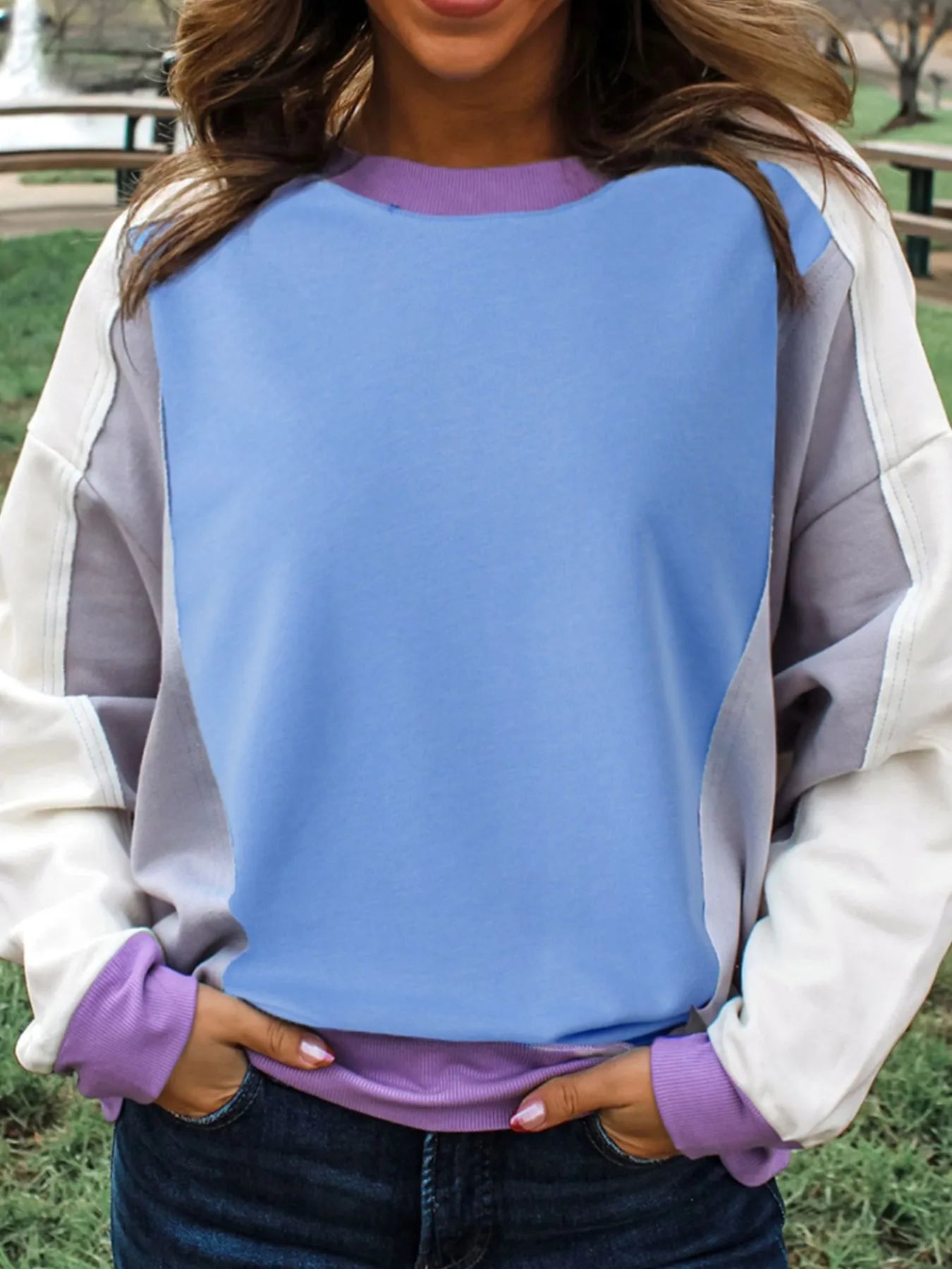 Person wearing a colorful sweater with a blue, purple, and gray design