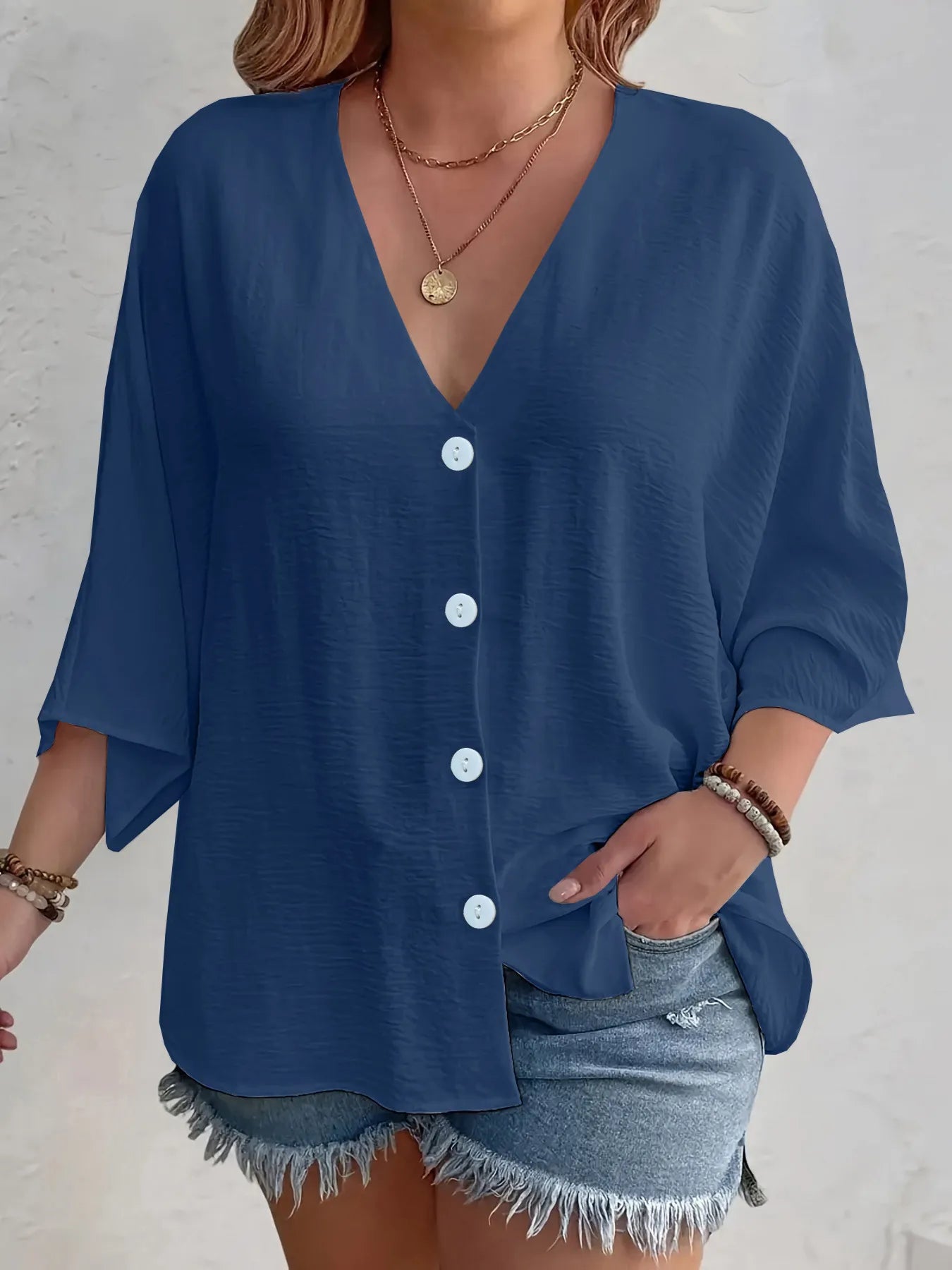 women’s blue button‑up shirt with denim shorts