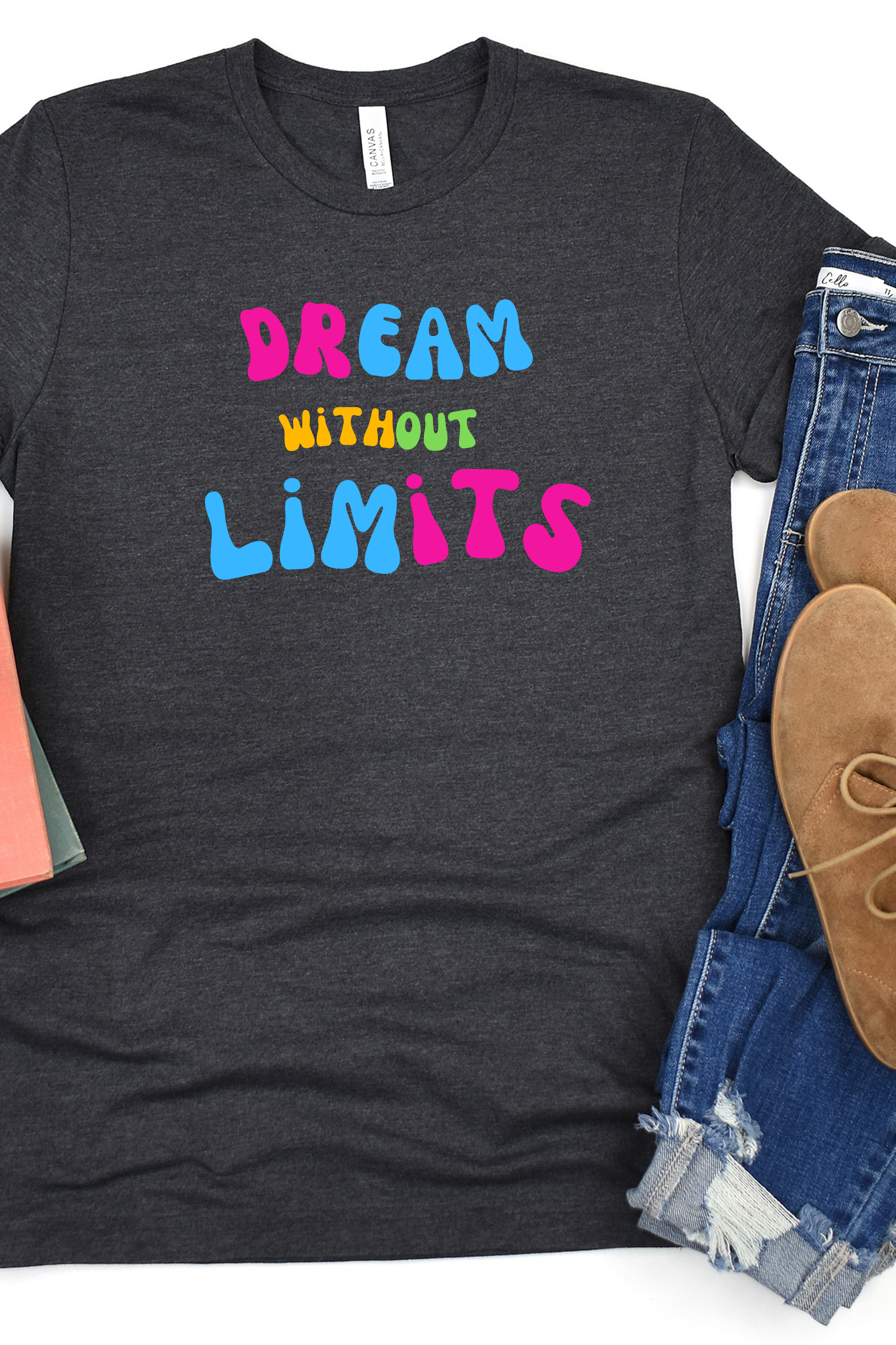 Dark gray t-shirt with 'Dream Without Limits' text in colorful letters, paired with jeans and shoes.