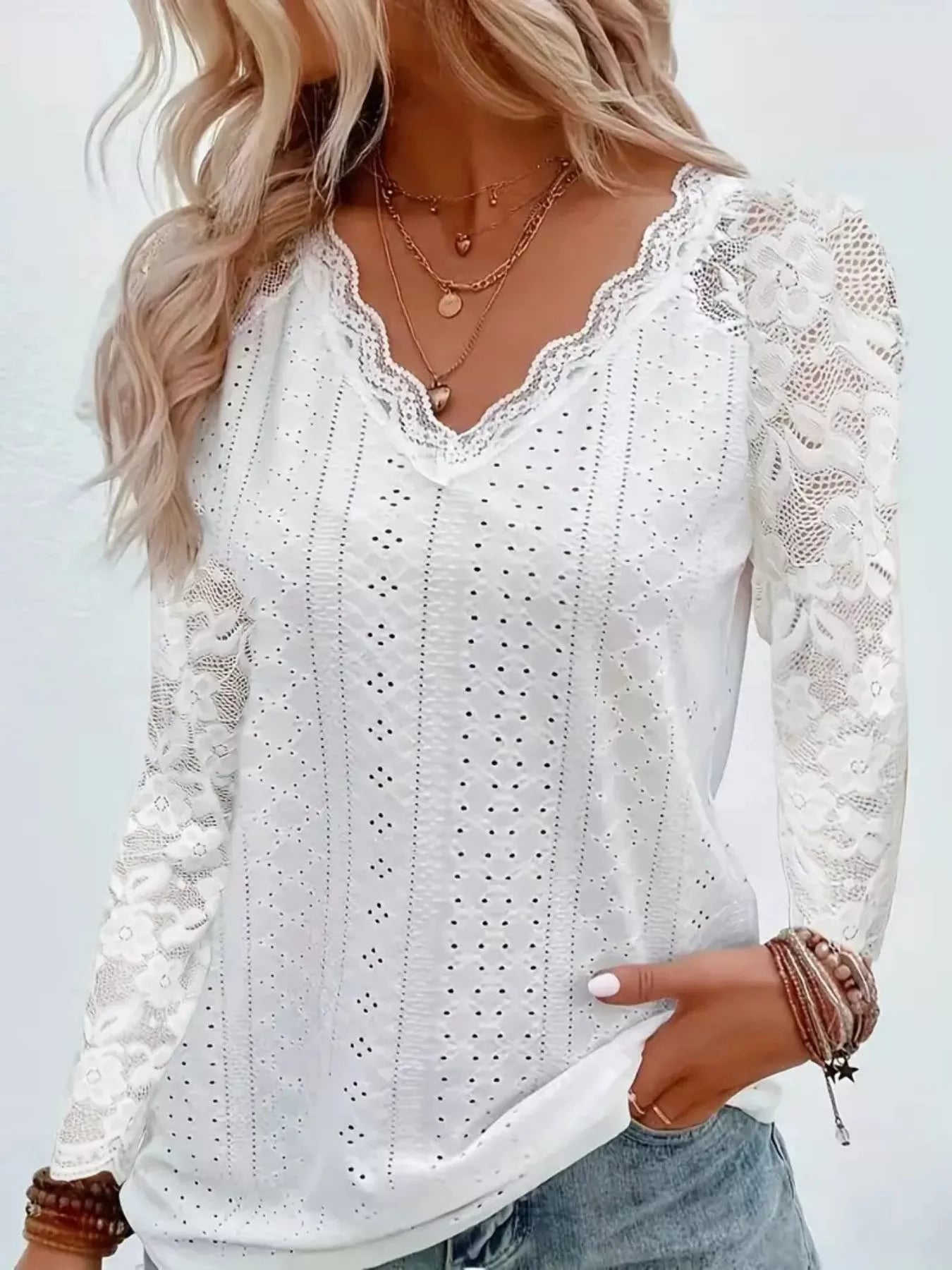 White lace top worn by a person with a plain background